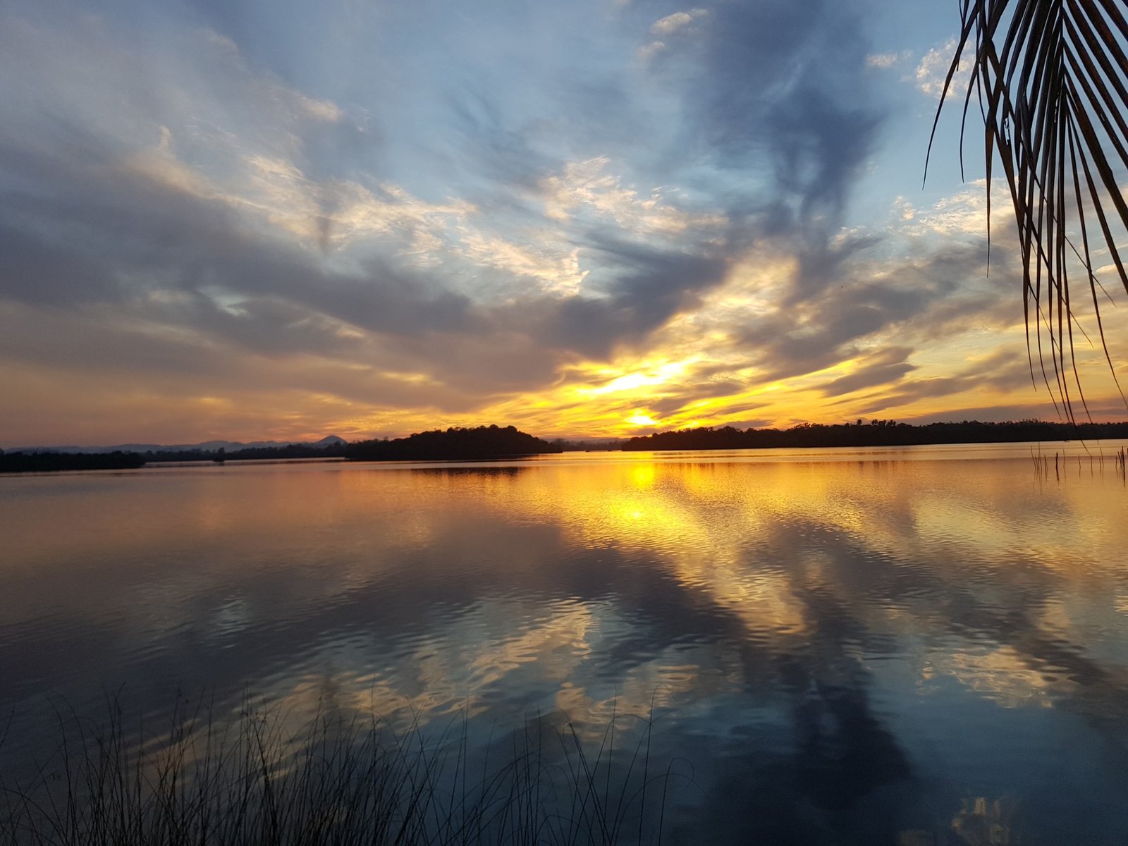 Golden sunrise over the calm waters of Madu Ganga